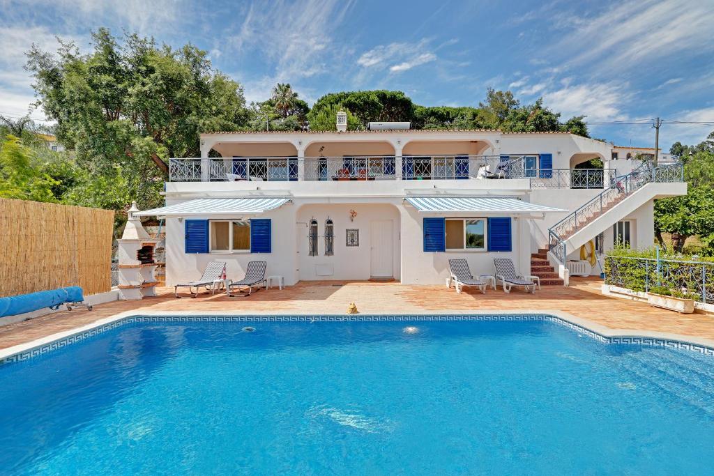 a villa with a swimming pool in front of a house at Casa dos Sonhos by Portucasa in São Brás de Alportel
