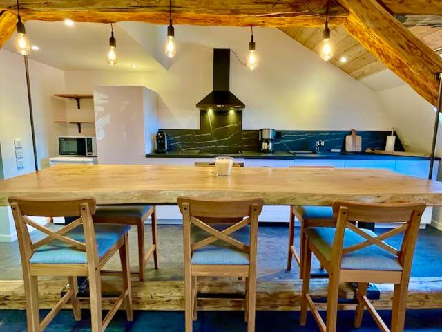 eine Küche mit einem großen Holztisch und Stühlen in der Unterkunft Superbe Loft - Centre Historique De Barcelonnette in Barcelonnette