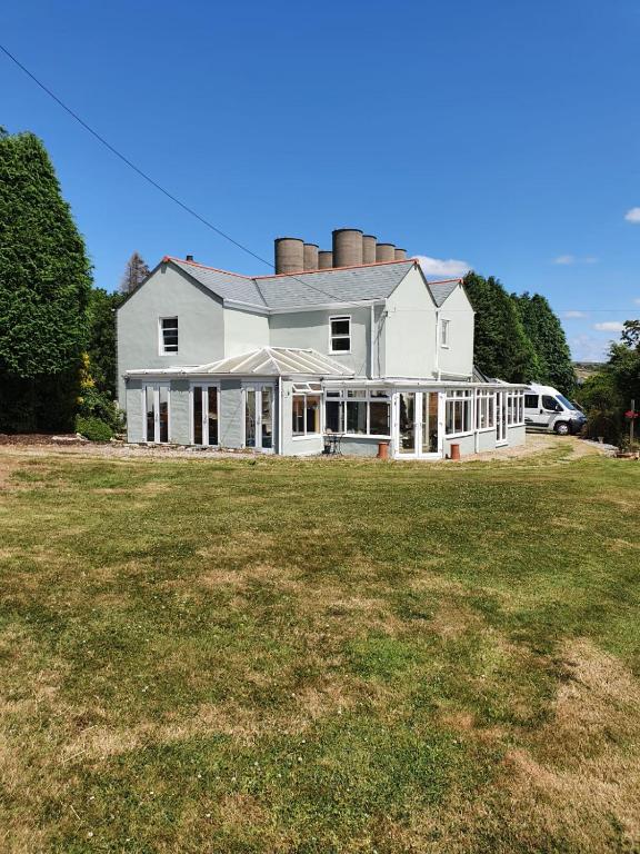 a large white house with a large yard at Station House in St Austell