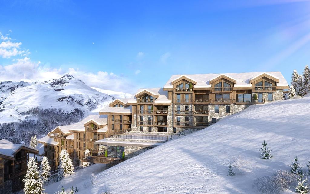 a resort in the mountains with snow on the ground at HIGALIK HOTEL in Les Menuires