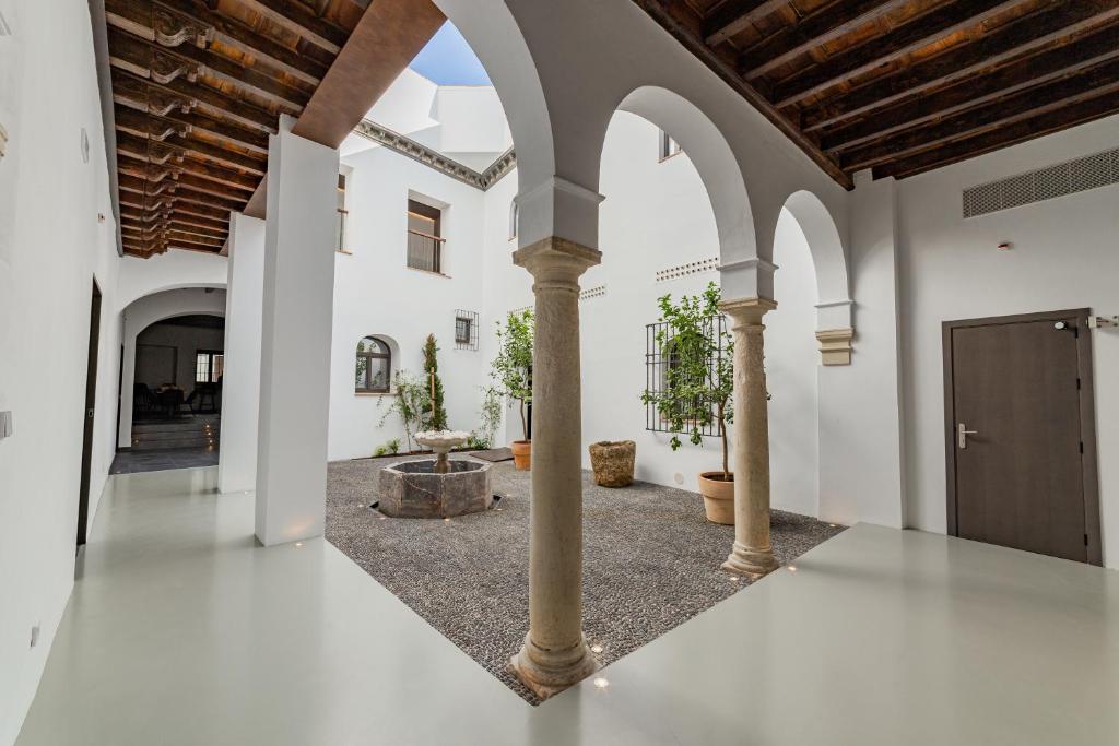 un couloir vide avec des murs blancs et des plafonds voûtés dans l'établissement Casa del Cardenal, à Cordoue