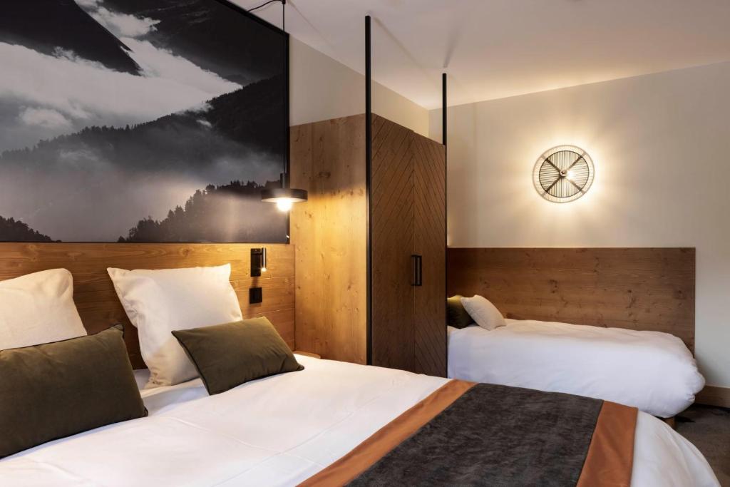 a hotel room with two beds and a picture on the wall at HIGALIK HOTEL in Les Menuires