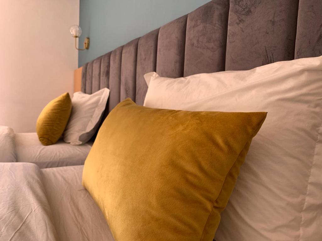 Royal Hotel Rabat في الرباط: سرير عليه وسائد بيضاء و صفراء
