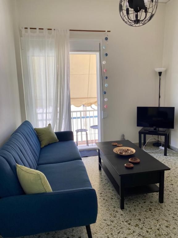 uma sala de estar com um sofá azul e uma mesa de centro em DARSISS - Agrinio Museum apartment em Agrinio