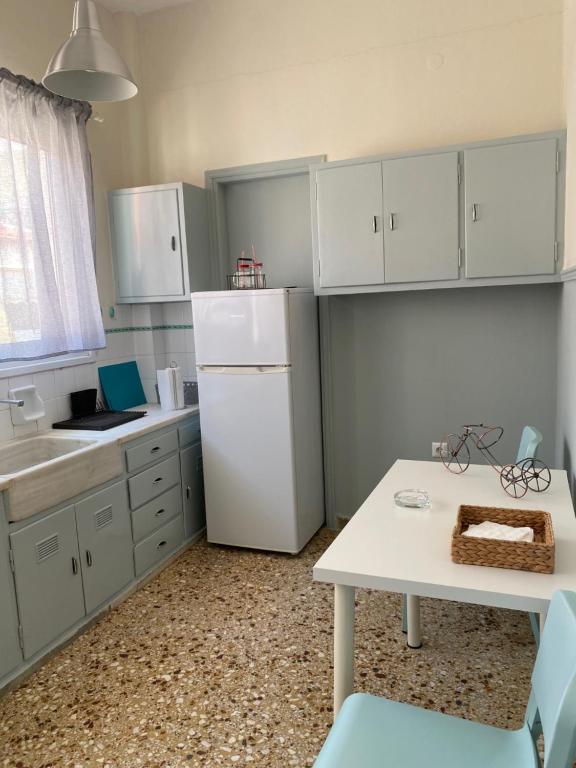 kuchnia z białymi szafkami i białą lodówką w obiekcie DARSISS - Agrinio Museum apartment w mieście Agrinio