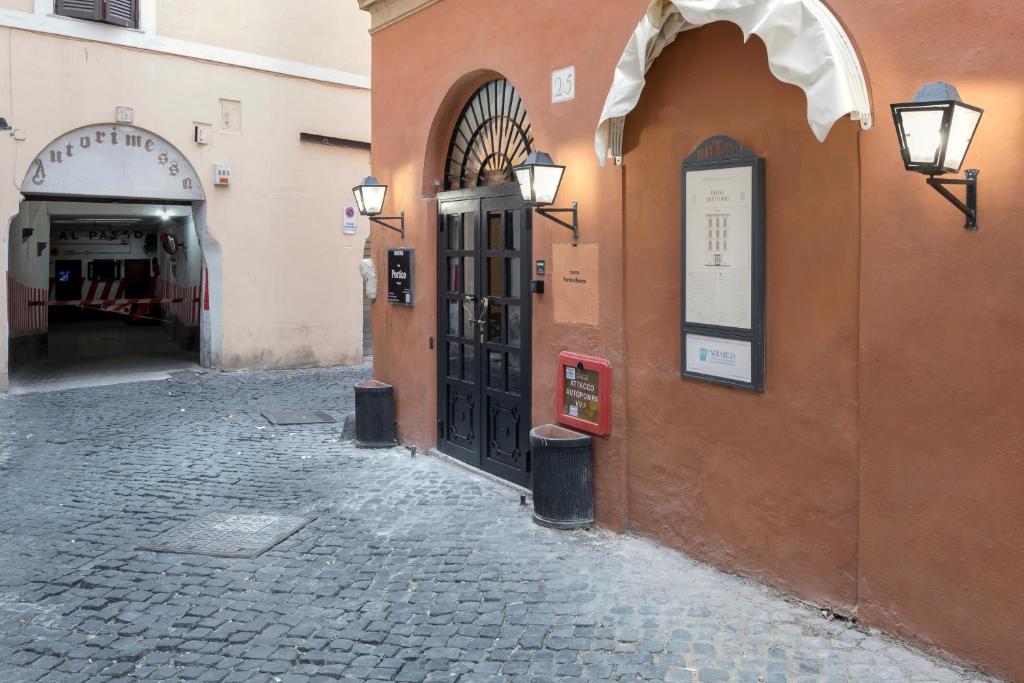 un vicolo di ciottoli con una porta su un edificio di numa I Portico a Roma
