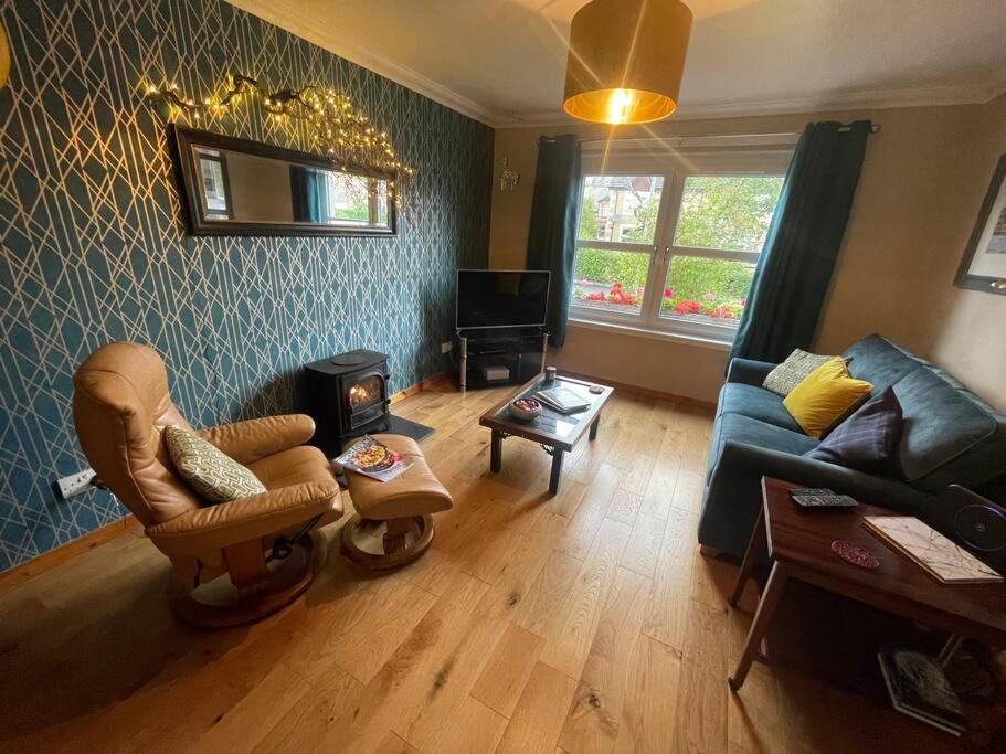 a living room with a couch and a chair at Beautiful Peebles Bungalow in Peebles