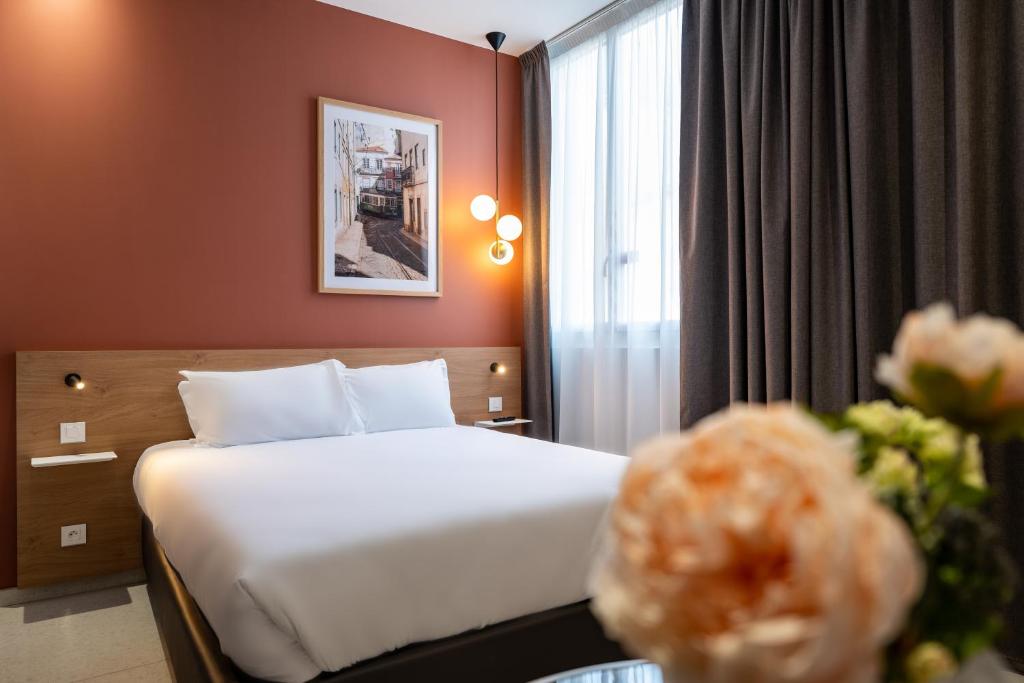 una camera d'albergo con un letto e una finestra di Corner-Set Cholet Centre a Cholet