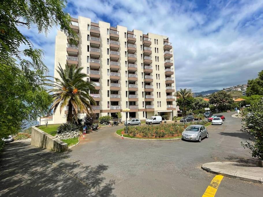 un grand bâtiment avec des voitures garées dans un parking dans l'établissement Vista Formosa, à Funchal