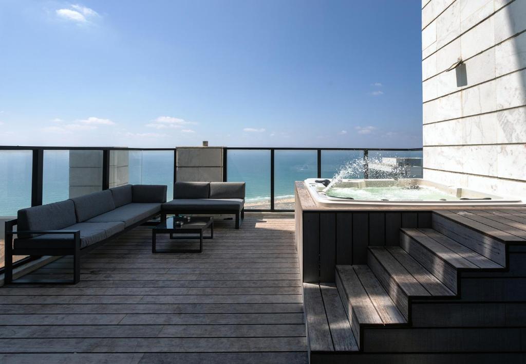 a balcony with a couch and a hot tub on a building at YalaRent sea-breeze penthouse with jacuzzi in Bat Yam