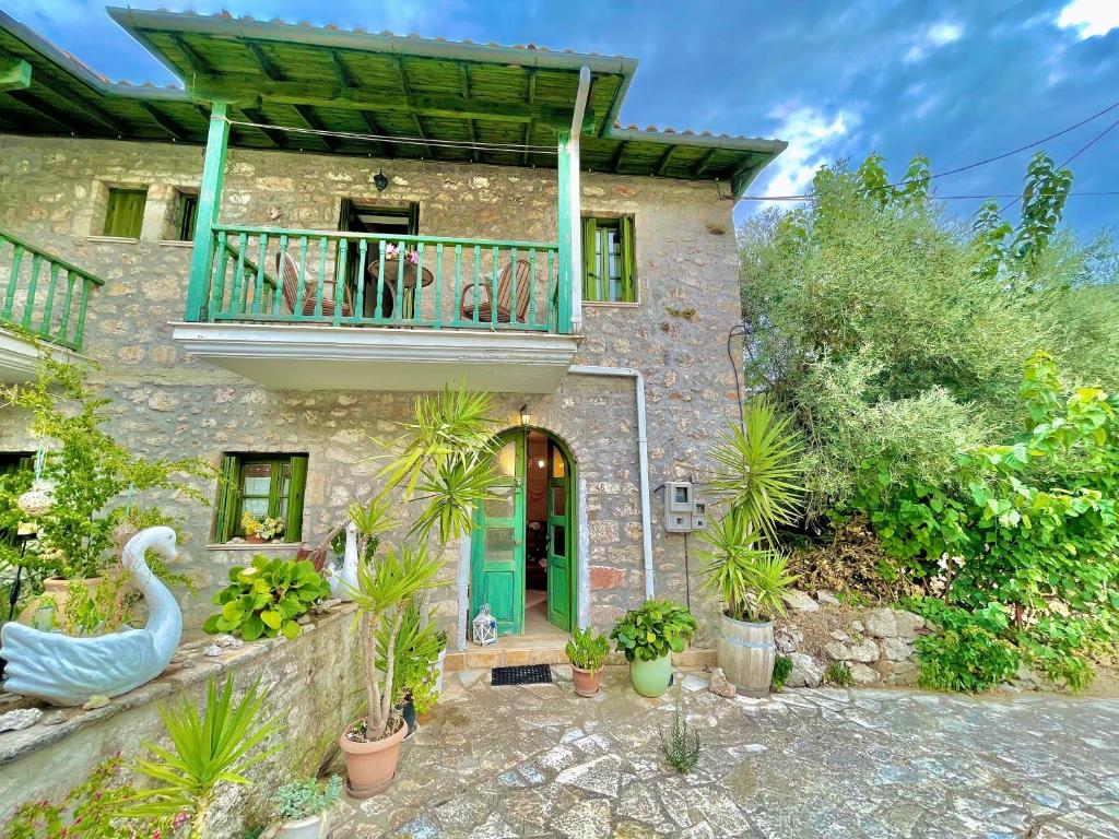 uma casa com varanda e um cisne em frente em Petra Maisonettes em Kariá