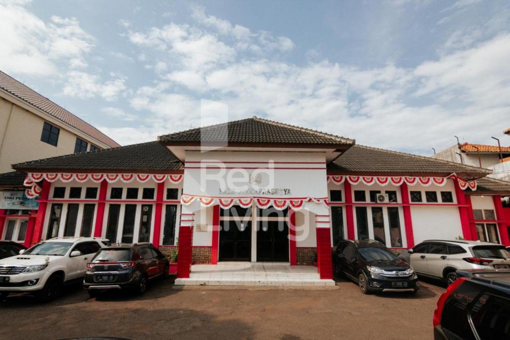 un bâtiment rouge et blanc avec des voitures garées dans un parking dans l'établissement KORPRI Live House RedPartner, 