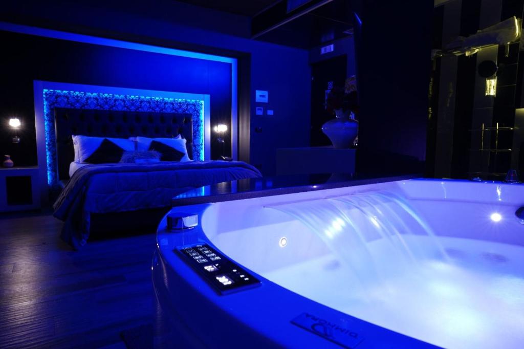 Hotel Angioino & Spa في نابولي: غرفة نوم زرقاء مع سرير وحوض استحمام