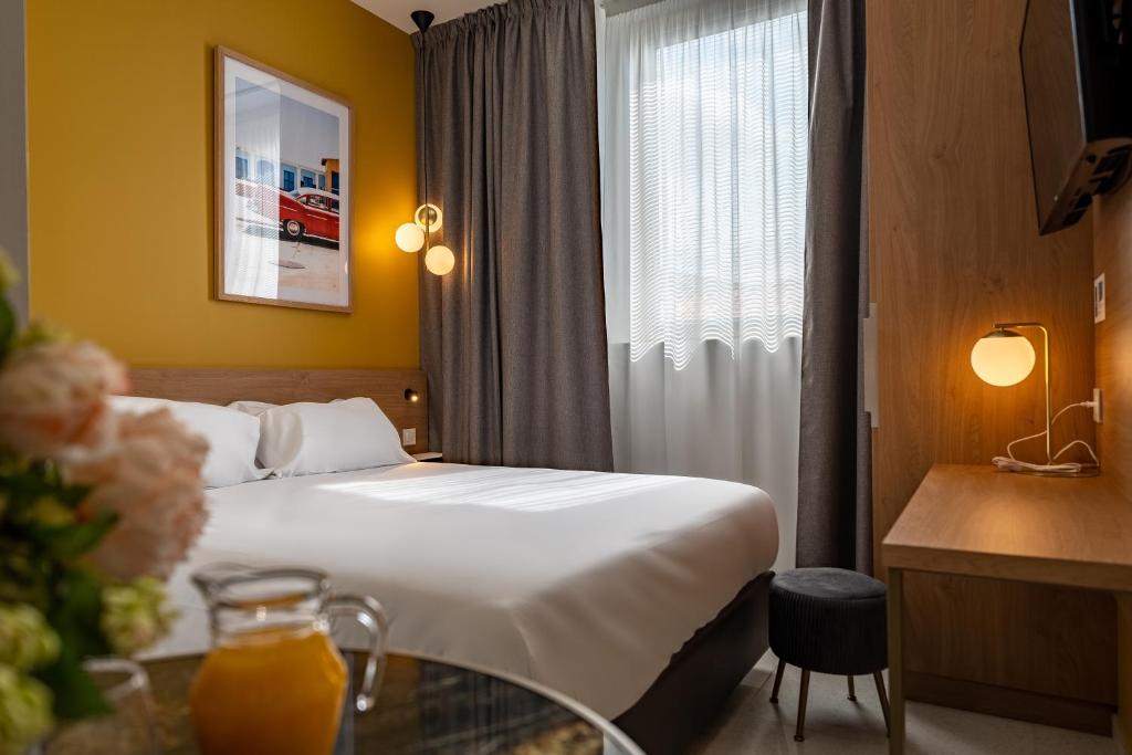 una camera d'albergo con letto e tavolo in vetro di Corner-Set Cholet Centre a Cholet