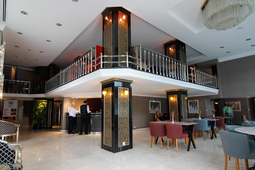 a restaurant with a staircase and tables and chairs at Sogut Hotel Old City in Istanbul