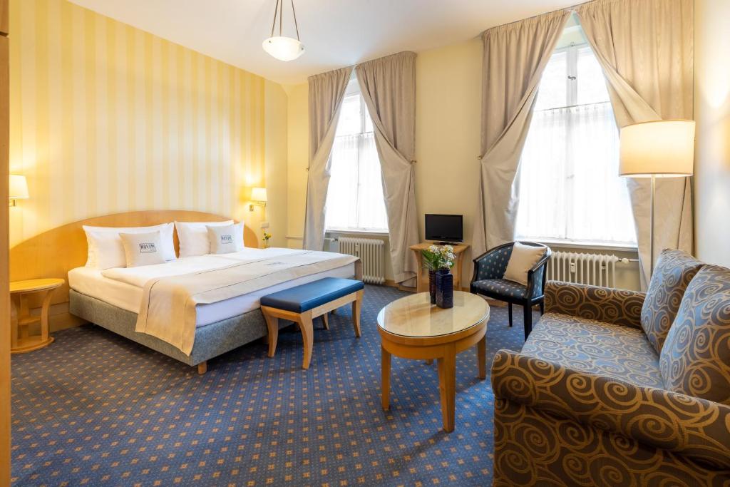 ベルリンにあるノヴムホテル クロンプリンツベルリンのベッドとソファ付きのホテルルーム