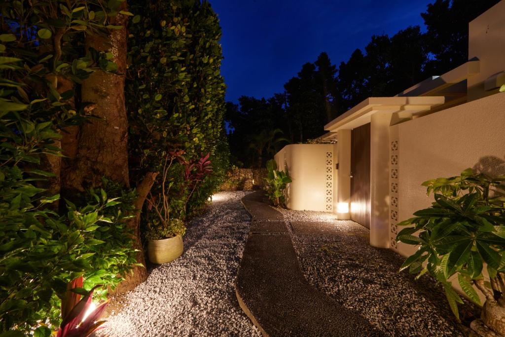 a garden path with plants and lights at night at Private Villas Ryuz備瀬 in Motobu