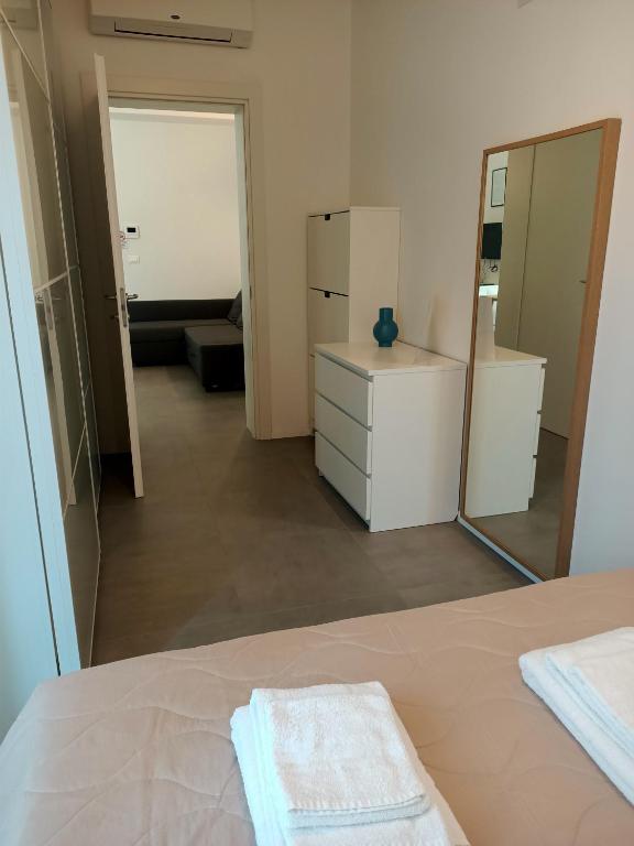 Pokój z łóżkiem i lustrem oraz pokój z komodą w obiekcie Bologna House Residence w Bolonii