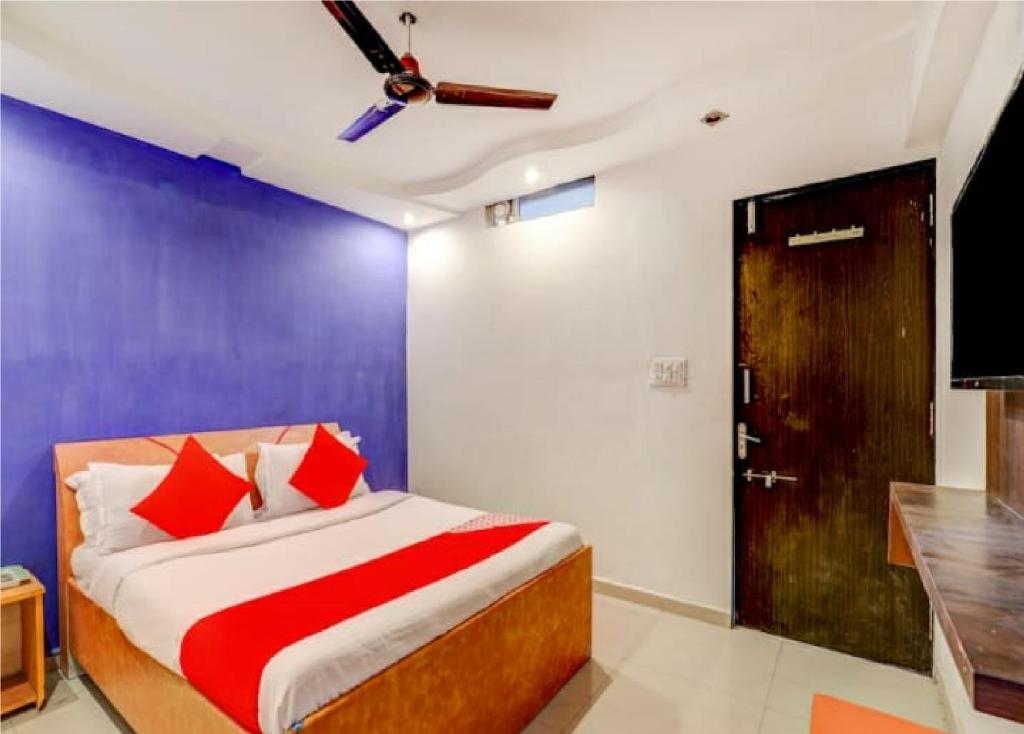 Hotel Sangam في أحمد آباد: غرفة نوم بسرير ومروحة سقف