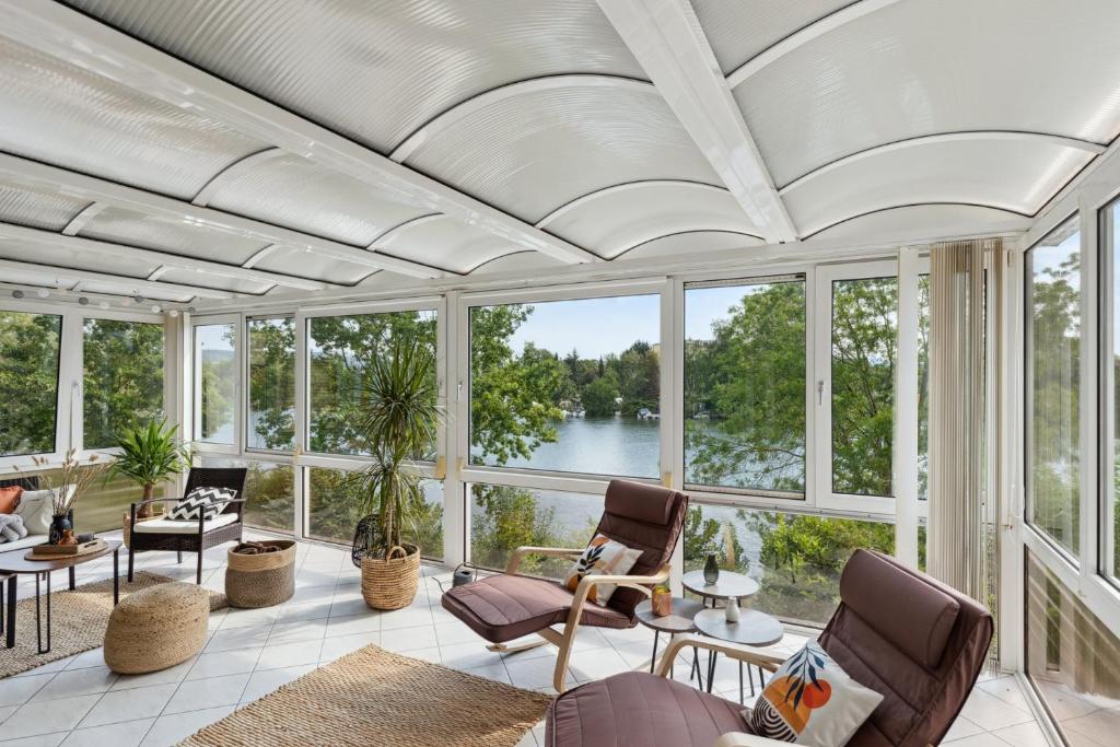 an open living room with a view of the water at Charysma - Chillout-Loft, Wintergarten, E-Kamin, Massage-Sessel, Schlafzimmer mit Smart-TV, 2 Parkplätze in Hameln