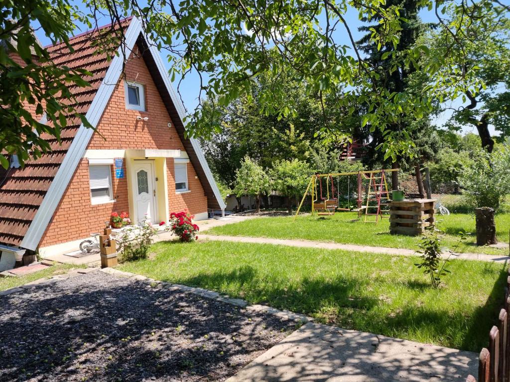 a house with a yard with a playground at Kuća za odmor Apathy in Opatovac
