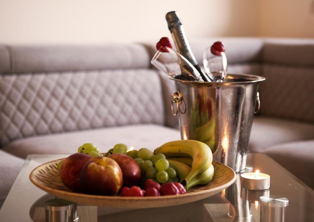talerz owoców na stole z butelką szampana w obiekcie Wellness Apartman Vrakuna w Bratysławie