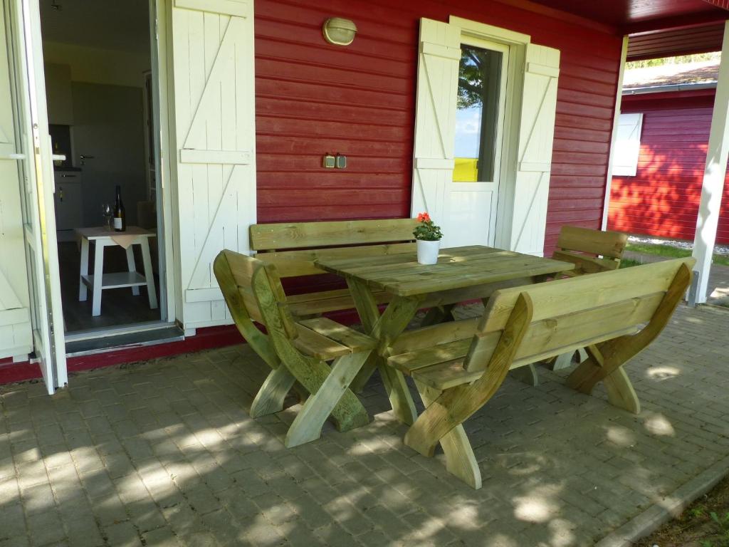 a wooden table and benches on a patio at Bernsteinreiter Erlebnishof Barth, Blockhütte 20 in Barth