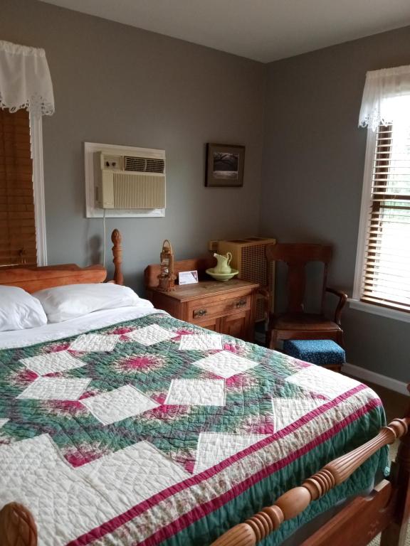 a bedroom with a quilt on top of a bed at Laughing Heart Lodge in Hot Springs