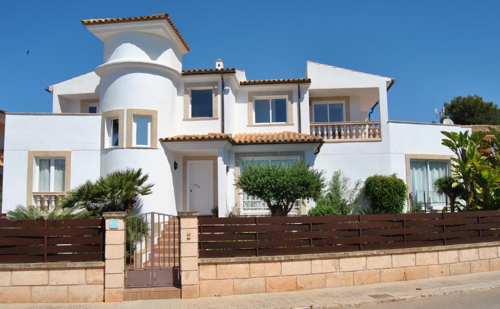 a white house with a fence in front of it at Villa Teresa in Colonia Sant Jordi