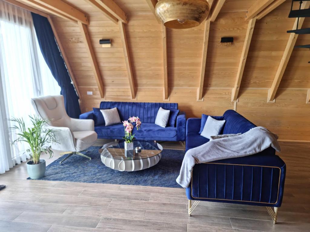 a living room with blue couches and a table at Batllava Premium Resort Villa 2 in Orllan