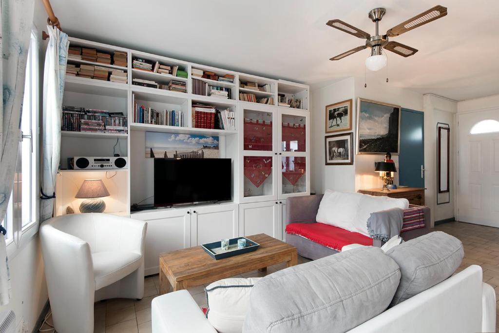 a living room with white furniture and a flat screen tv at Ostréane-en-Ré in Rivedoux-Plage