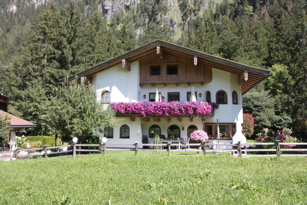 ein Haus mit Blumen auf der Vorderseite in der Unterkunft Vronis Waldhaus ADULTS ONLY in Mayrhofen