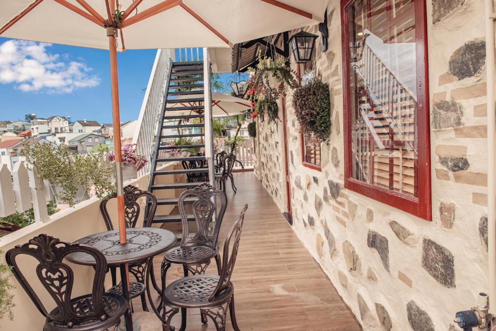 a patio with tables and chairs on a balcony at Villa Hoa Da in Da Lat