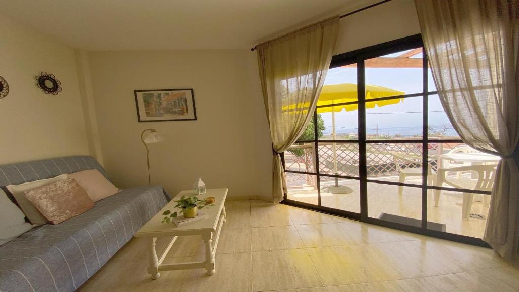 巴列格蘭雷的住宿－La Tajea del Turno，带沙发和桌子的客厅以及阳台。
