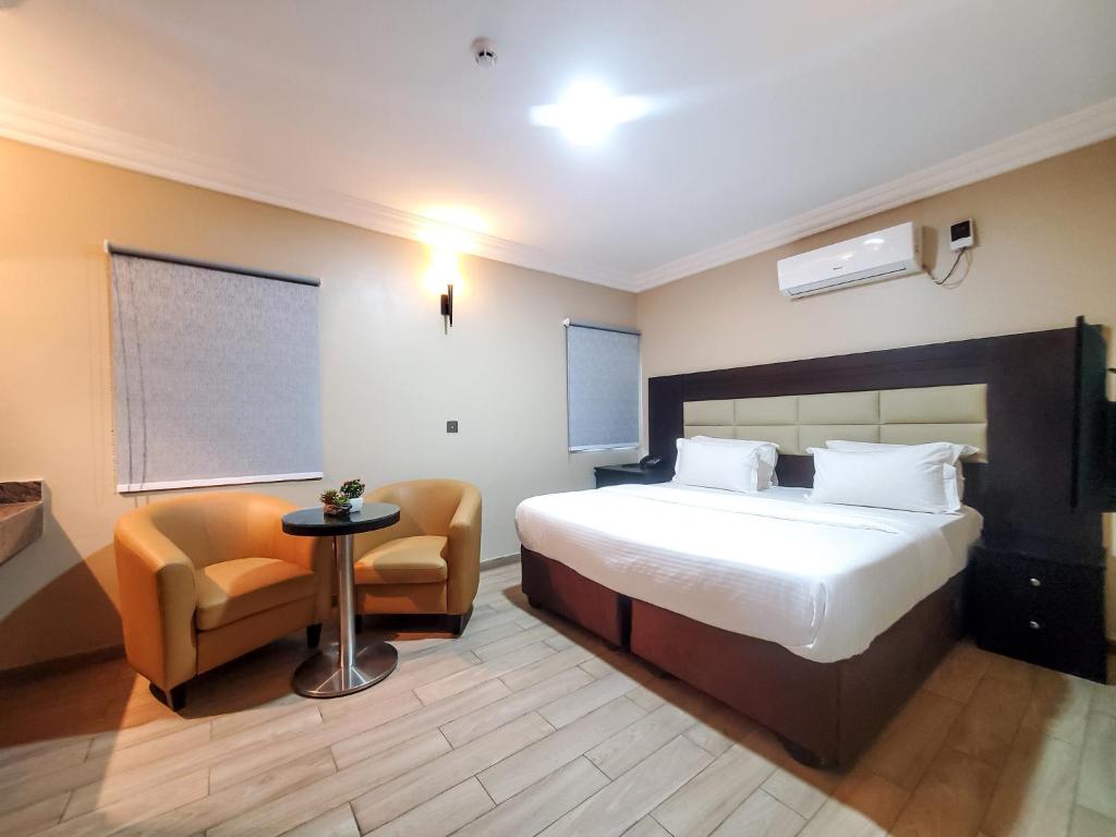 a bedroom with a bed and a table and a chair at Fadar's Place Hotel in Sagisa