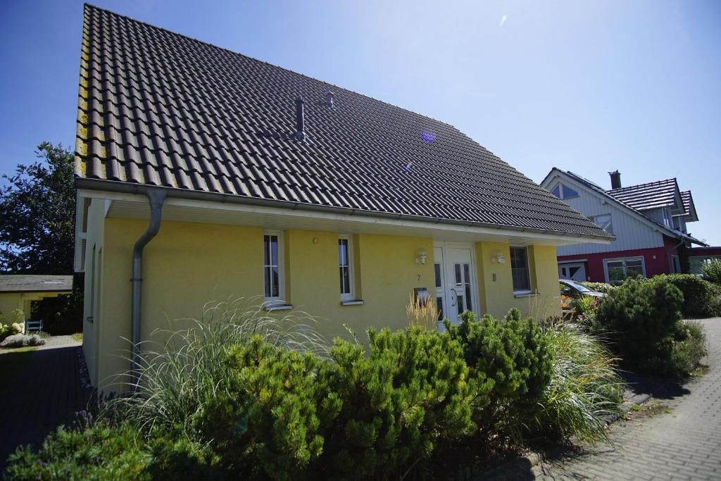 une maison jaune avec un toit noir dans l'établissement nah am Meer, Meerblick, gratis Nutzung vom AHOI Erlebnisbad und Sauna in Sellin - Haus Inselblick FeWo 03, à Göhren