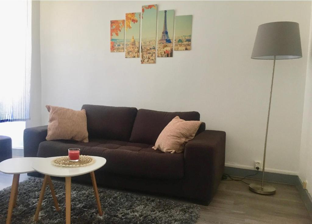 ein Wohnzimmer mit einem Sofa und einem Tisch in der Unterkunft Charmant T2 proche vieille ville in Montluçon
