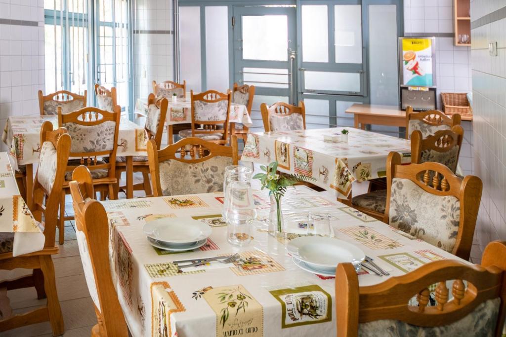 jadalnia ze stołami i krzesłami z białymi obrusami w obiekcie Zsóry Liget Vendégház w Mezőkövesd