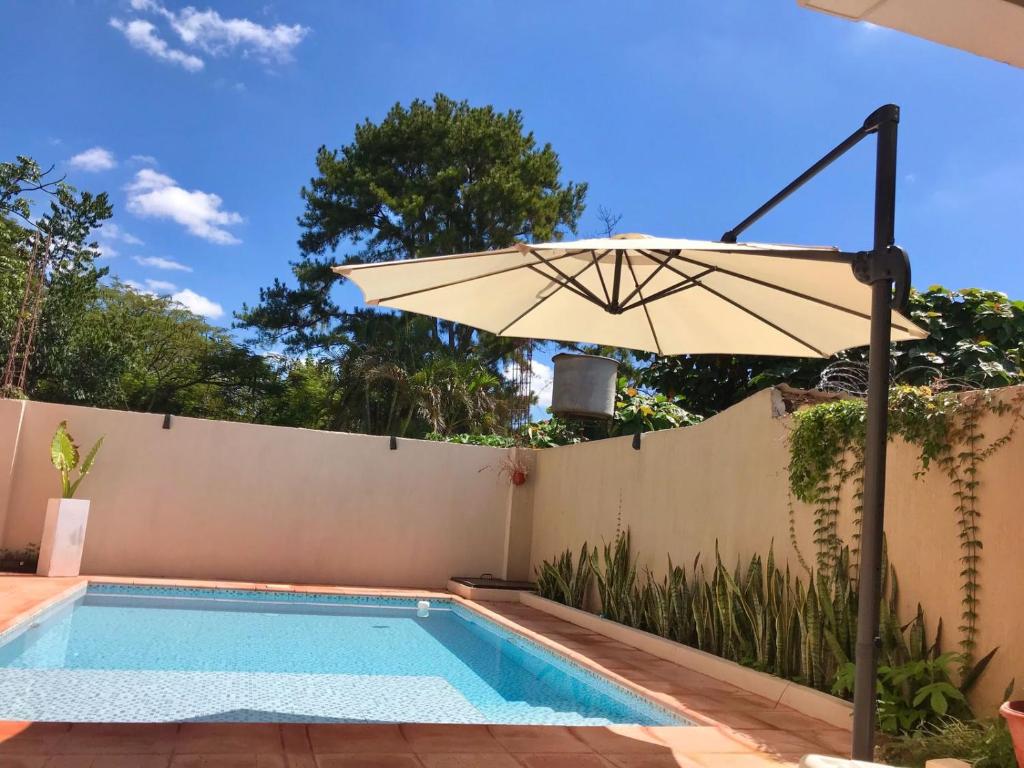 an umbrella next to a swimming pool at Colibrí Hostel in Puerto Iguazú