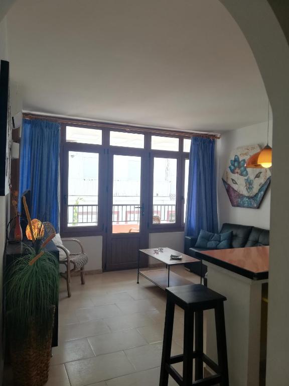 salon z niebieskimi zasłonami, kanapą i stołem w obiekcie Apartamentos Trocadero Ap18 w mieście Torremolinos