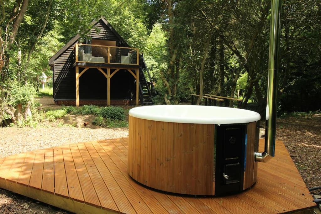 einen Whirlpool auf einer Holzterrasse mit einem Haus in der Unterkunft The Hive - beautiful studio with amazing hot tub in Cratfield