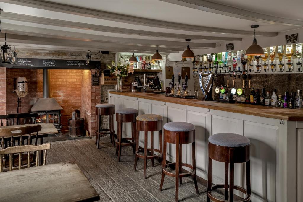 a bar with a row of stools in a room at The Olde Malthouse Inn in Tintagel