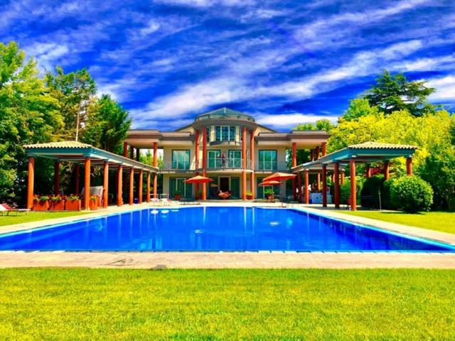 une grande maison avec une grande piscine en face de celle-ci dans l'établissement Ex Villa Gastaldi, à Asti