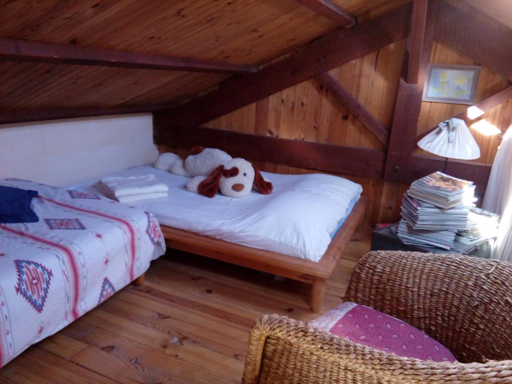 a bedroom with a bed with a stuffed dog on it at Comfortable Quiet House in the countryside Porte-du-Quercy for 8 people in Sérignac