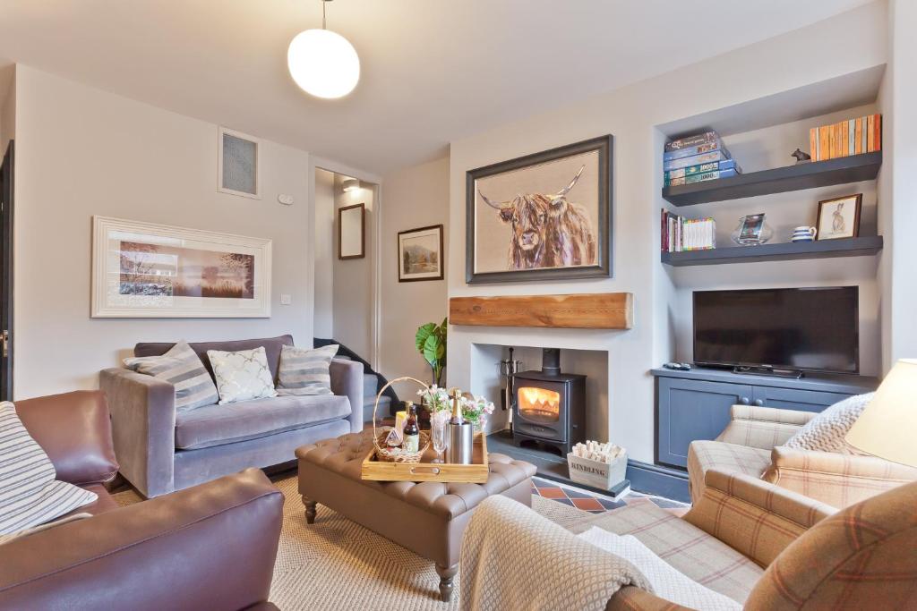 a living room with a couch and a fireplace at Bumble Choo Cottage - Windermere, Lake District in Windermere