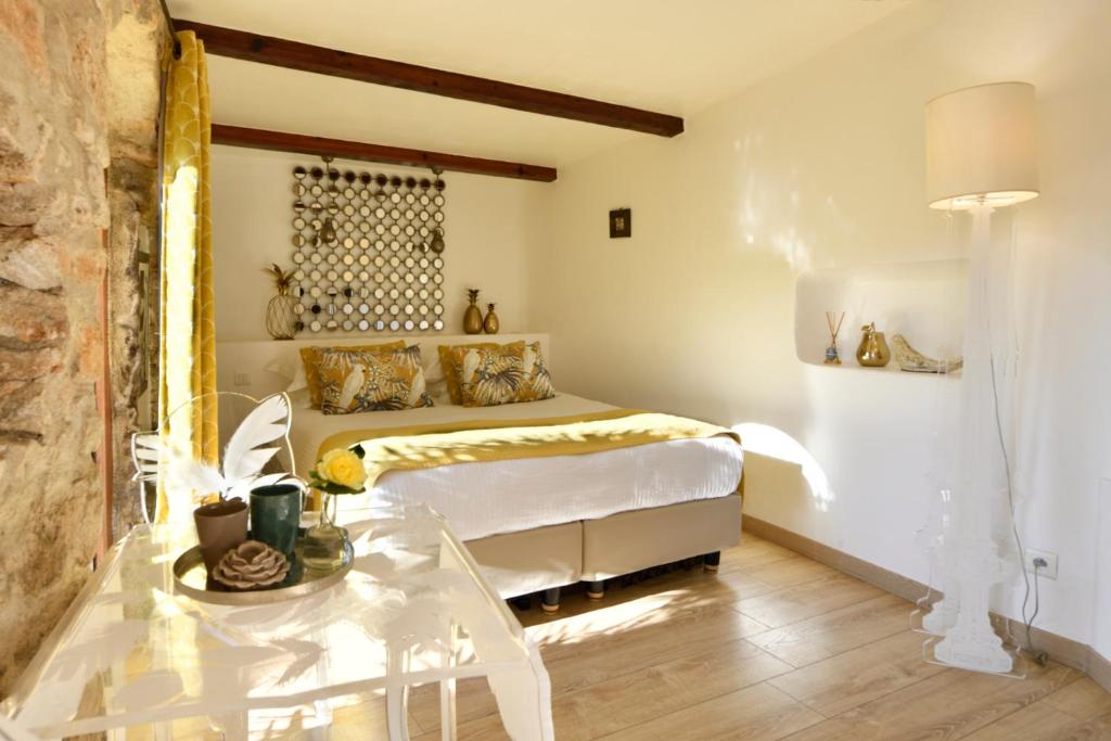 a bedroom with a bed and a table in it at Lodge de Charme A Cheda in Bonifacio