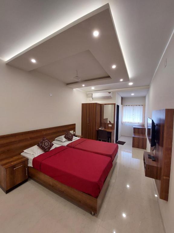 sypialnia z dużym czerwonym łóżkiem w pokoju w obiekcie FOUR SQUARE COMFORTS w mieście Manipala