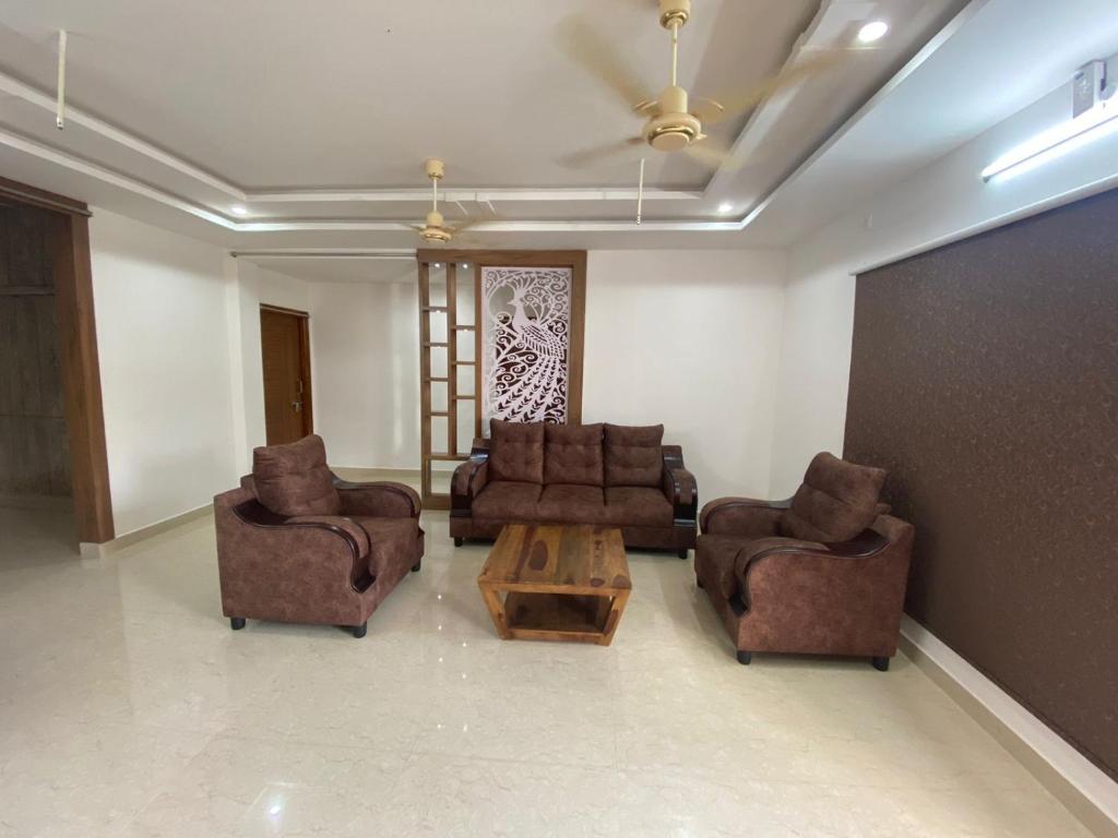 Sala de estar con sofás y mesa de centro en Ameya Homestays Brand New Fully Furnished 3BHK & 2BHK Apartments. en Tirupati