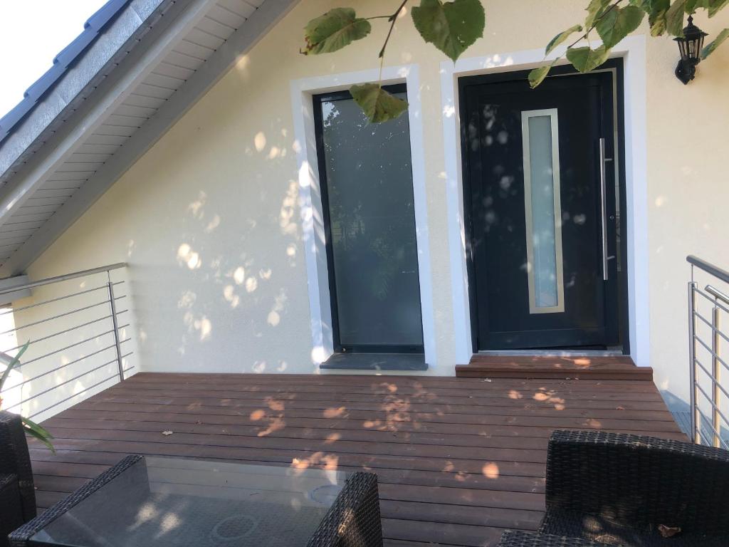 eine Veranda mit einer schwarzen Tür und einem Fenster in der Unterkunft Zimmervermietung Krug in Eberhardzell
