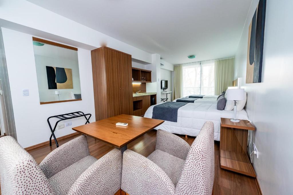 Habitación de hotel con cama, mesa y sillas en Hotel Bys Palermo en Buenos Aires